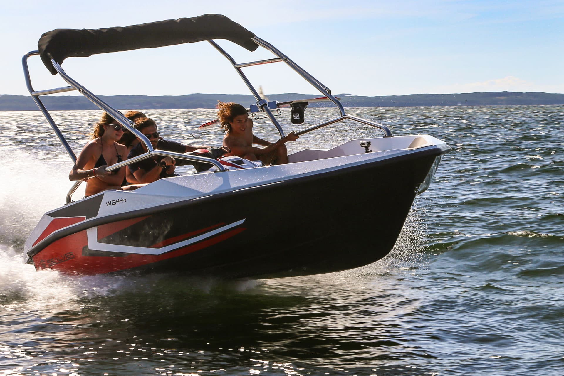 WB 444 — łódź z bimini w ruchu, osoby na pokładzie