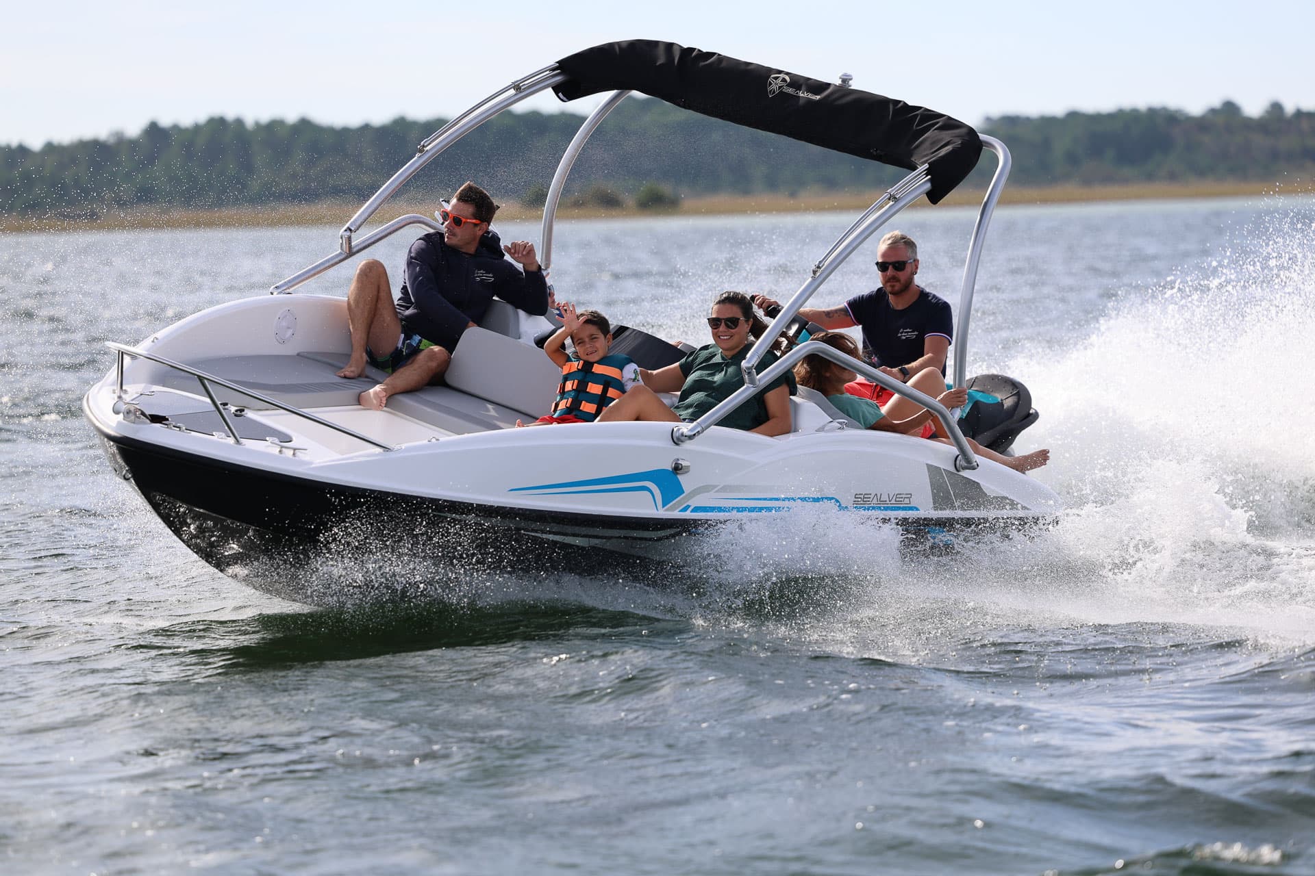WB 525 — łódź z bimini w ruchu, osoby na pokładzie
